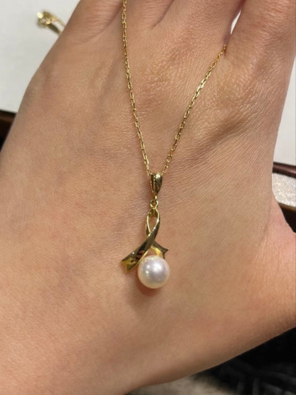 K18 gold necklace with single pearl and ribbon-shaped pendant on a white background