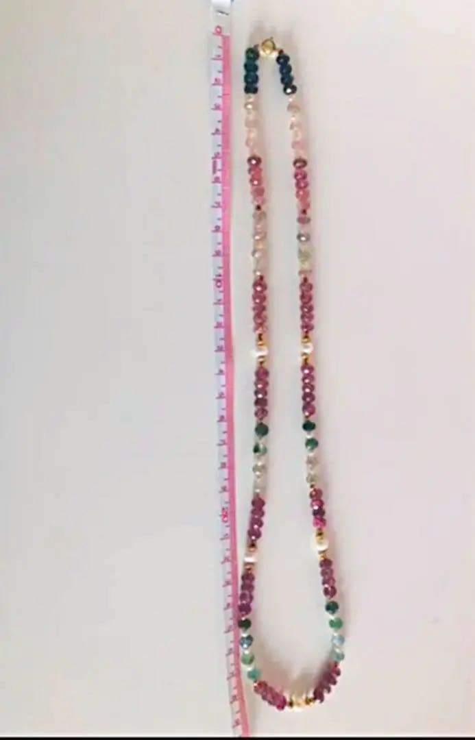 K18 gold necklace with 31 Akoya pearls and mixed cut tourmaline gemstones on display
