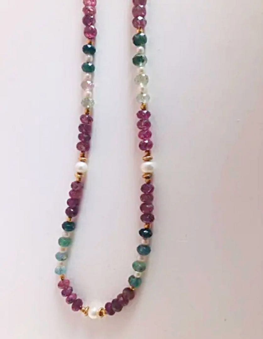 K18 gold necklace with 31 Akoya pearls and mixed cut tourmaline gemstones on display