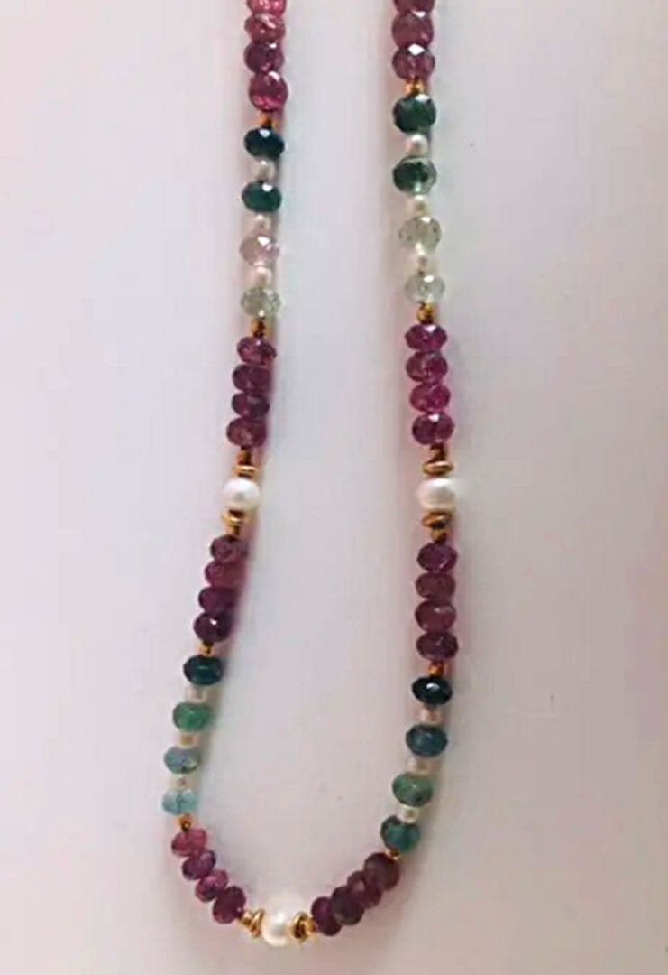 K18 gold necklace with 31 Akoya pearls and mixed cut tourmaline gemstones on display