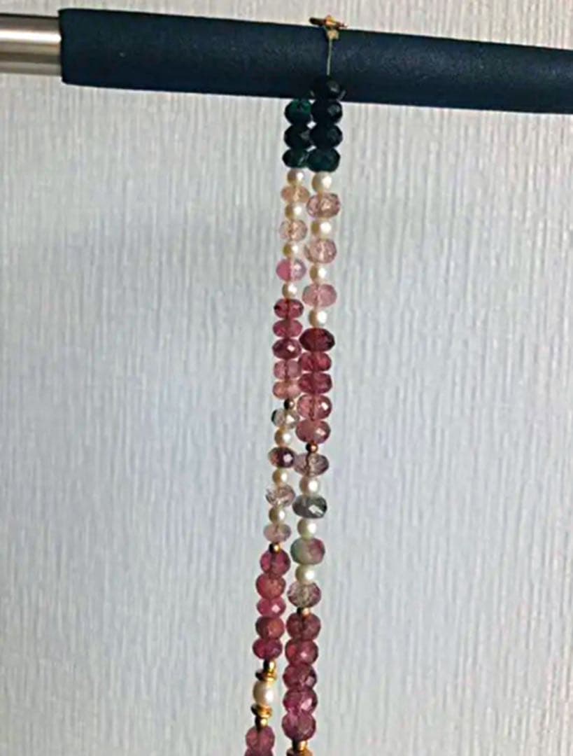 K18 gold necklace with 31 Akoya pearls and mixed cut tourmaline gemstones on display