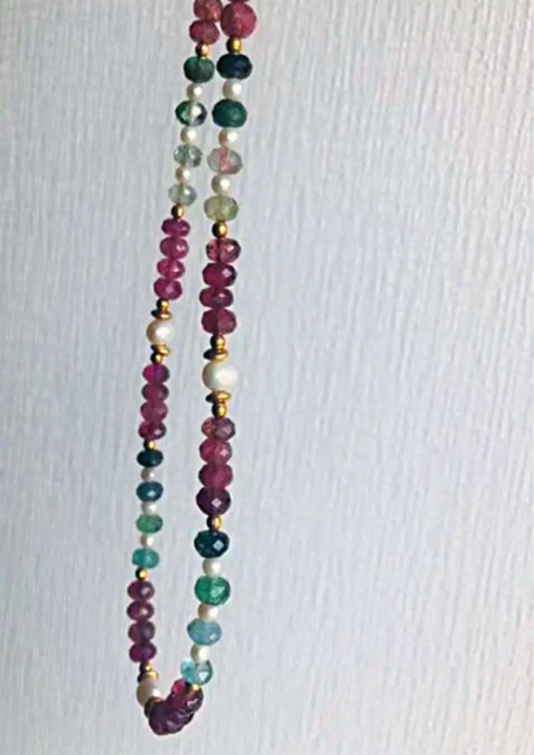 K18 gold necklace with 31 Akoya pearls and mixed cut tourmaline gemstones on display