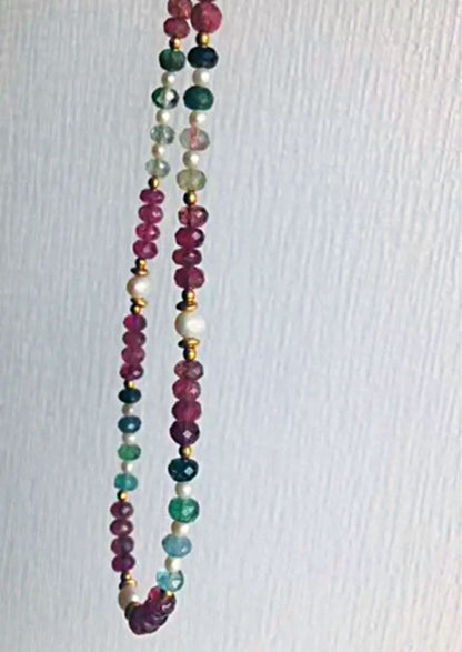 K18 gold necklace with 31 Akoya pearls and mixed cut tourmaline gemstones on display