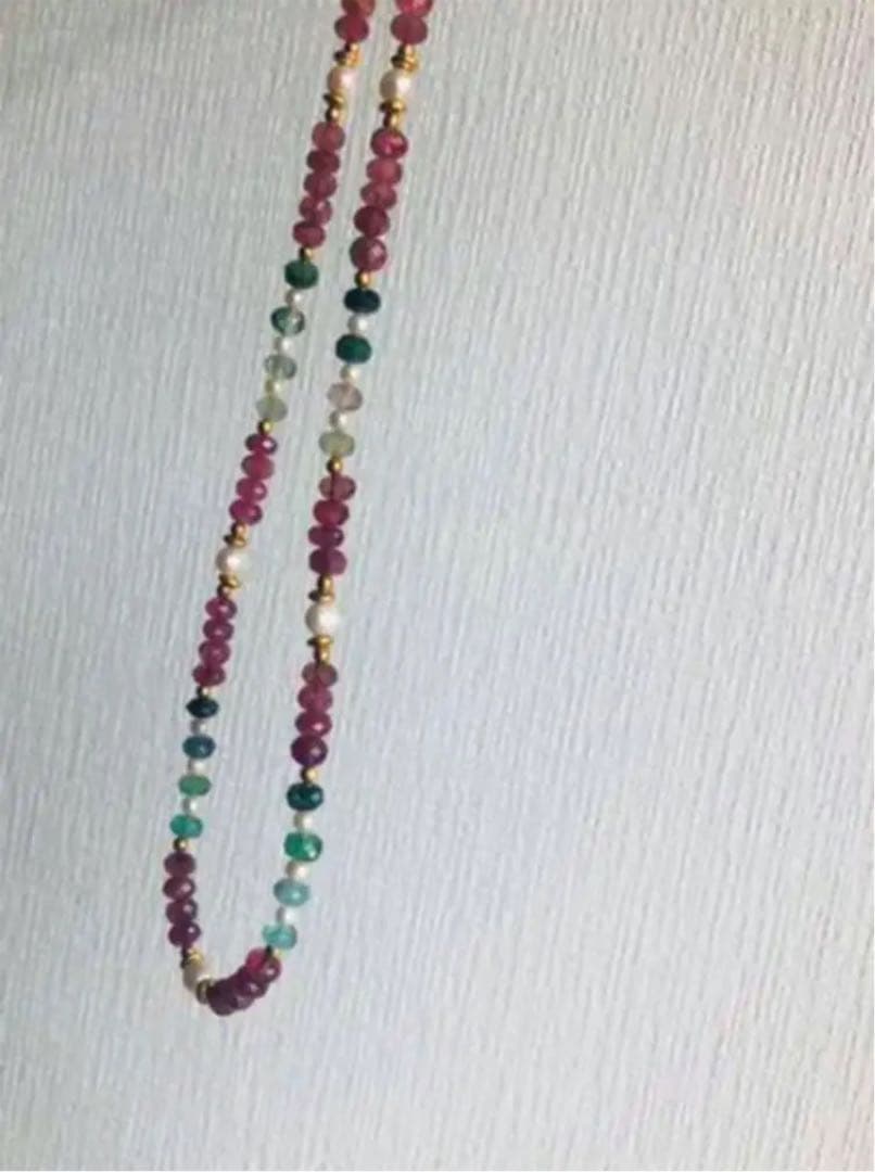 K18 gold necklace with 31 Akoya pearls and mixed cut tourmaline gemstones on display