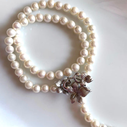 Akoya pearl necklace with 6mm white pearls and silver clasp showing pink and green interference colors