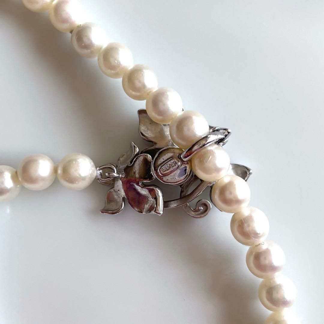 Akoya pearl necklace with 6mm white pearls and silver clasp showing pink and green interference colors