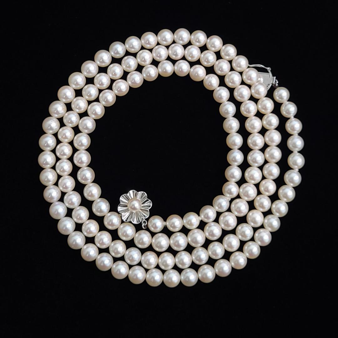 Akoya pearl necklace with 6mm pearls, 80cm length, silver clasp laid flat on white background