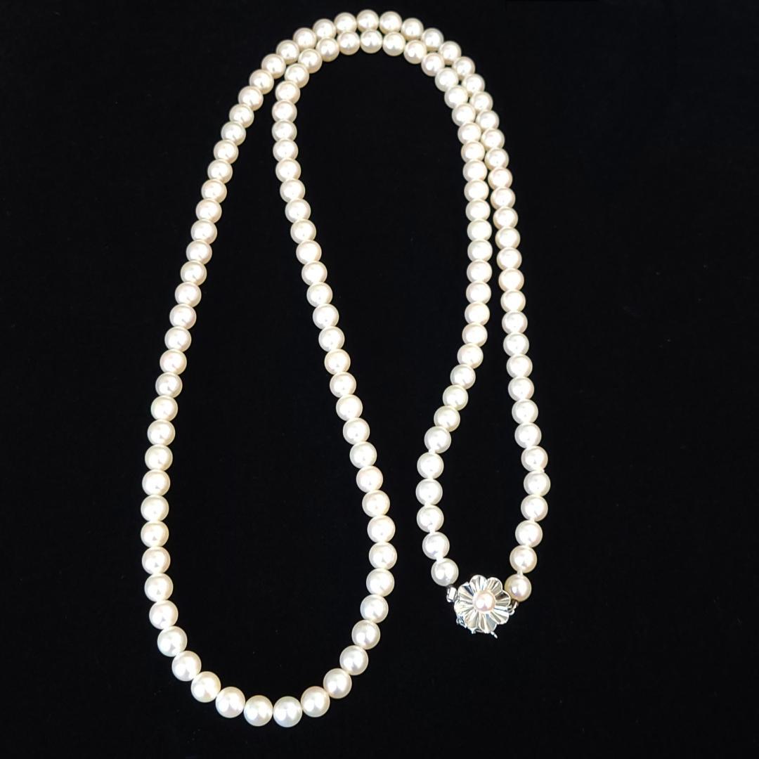 Akoya pearl necklace with 6mm pearls, 80cm length, silver clasp laid flat on white background