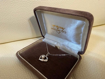 MIKIMOTO heart-shaped pearl necklace with silver pendant on white background