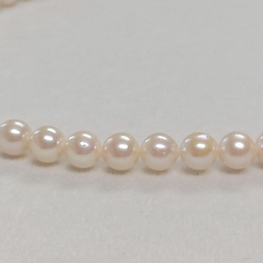 Law Akoya cultured pearl necklace with 6.5-7mm round white to cream pearls and silver clasp on a white background