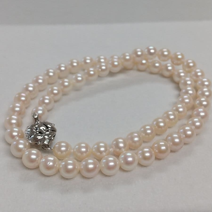 Law Akoya cultured pearl necklace with 6.5-7mm round white to cream pearls and silver clasp on a white background