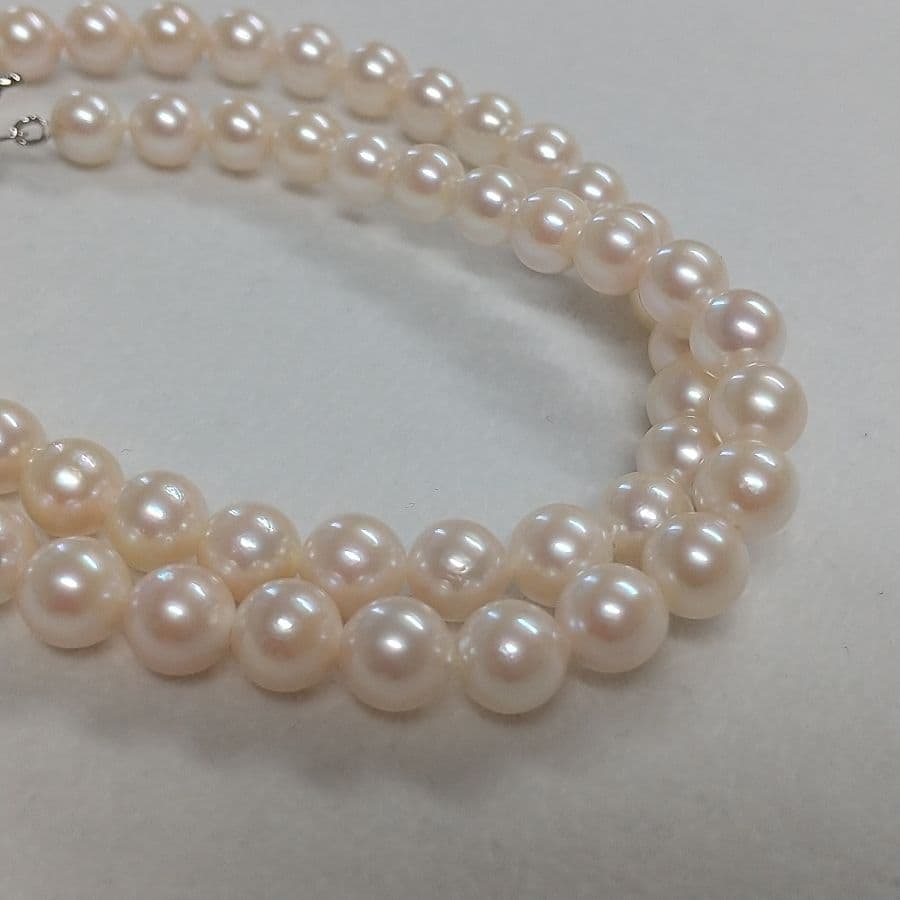 Law Akoya cultured pearl necklace with 6.5-7mm round white to cream pearls and silver clasp on a white background