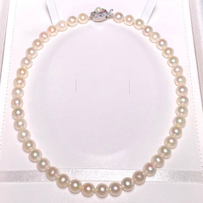 Oyster pearl necklace with round white pearls sized 8.3-8.8mm and ruby clasp with silver stamp
