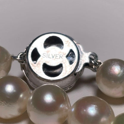 Oyster pearl necklace with round white pearls sized 8.3-8.8mm and ruby clasp with silver stamp