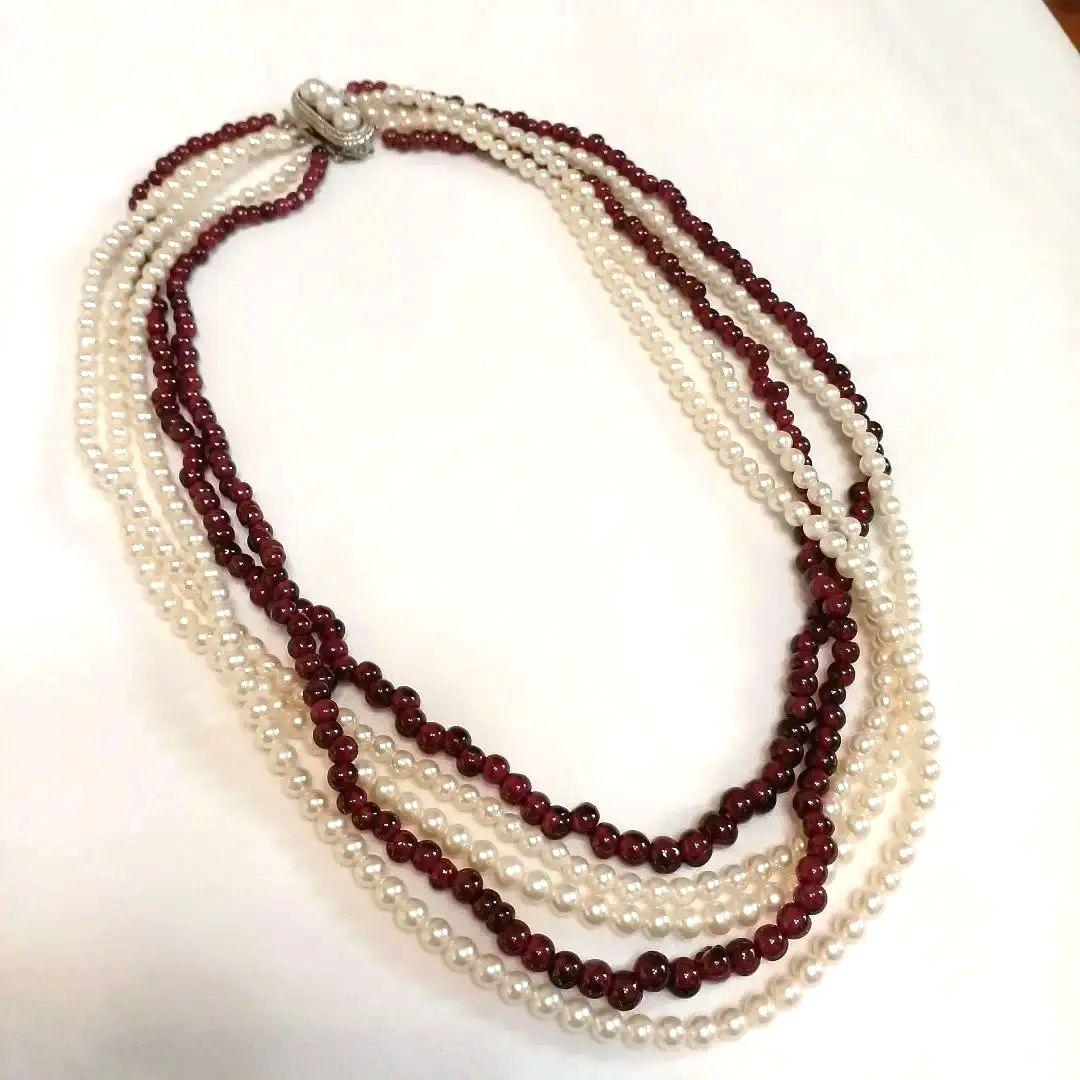 Five-row necklace with small round Akoya baby pearls and garnet stones showcasing high luster