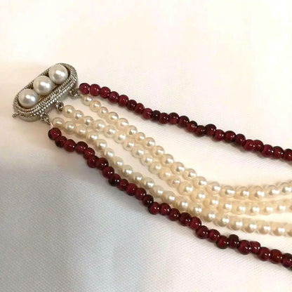 Five-row necklace with small round Akoya baby pearls and garnet stones showcasing high luster