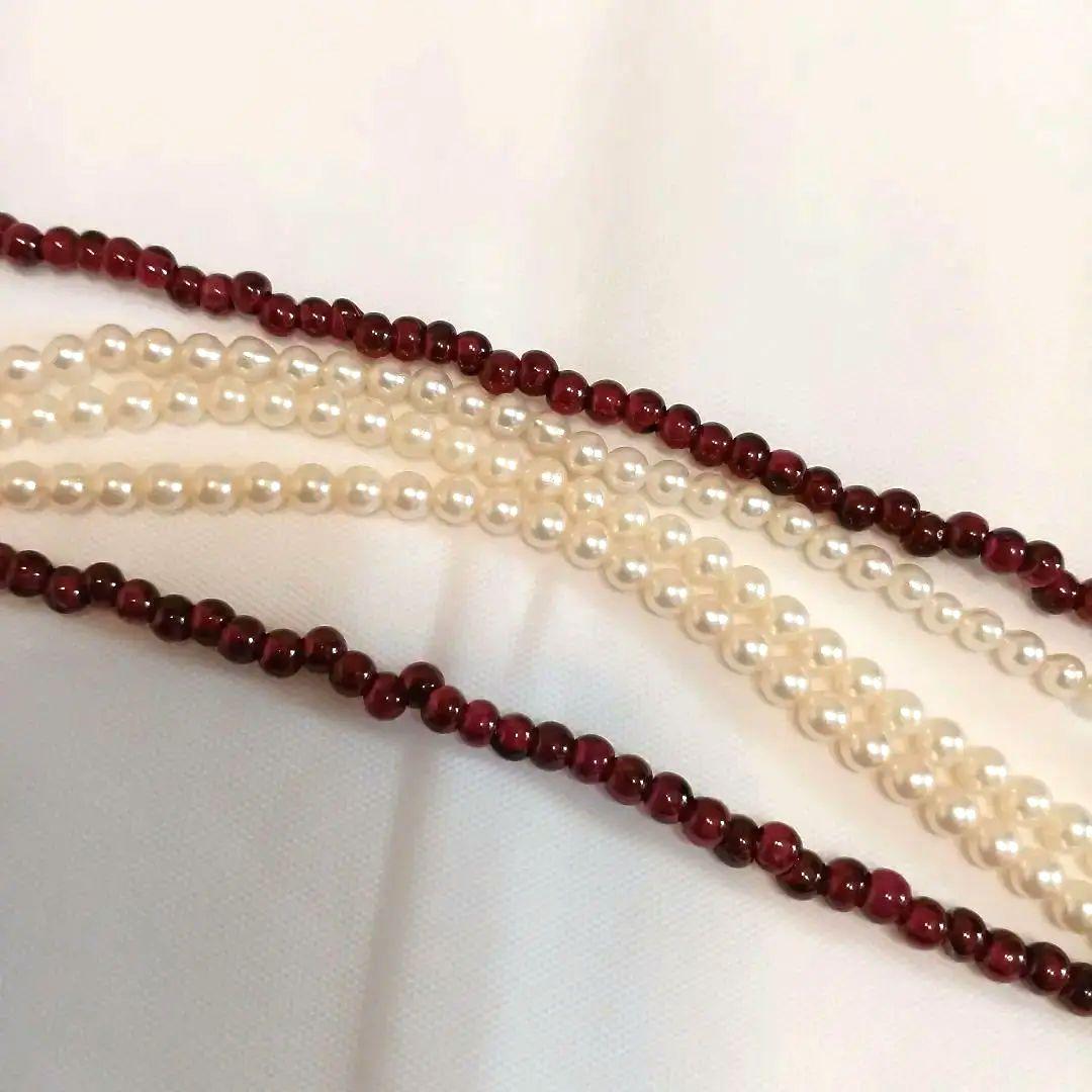 Five-row necklace with small round Akoya baby pearls and garnet stones showcasing high luster