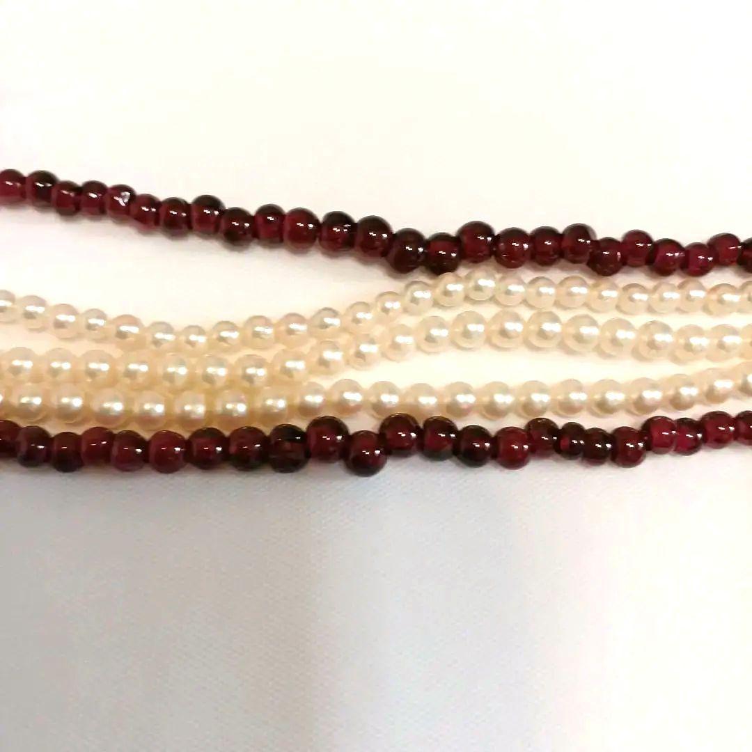 Five-row necklace with small round Akoya baby pearls and garnet stones showcasing high luster