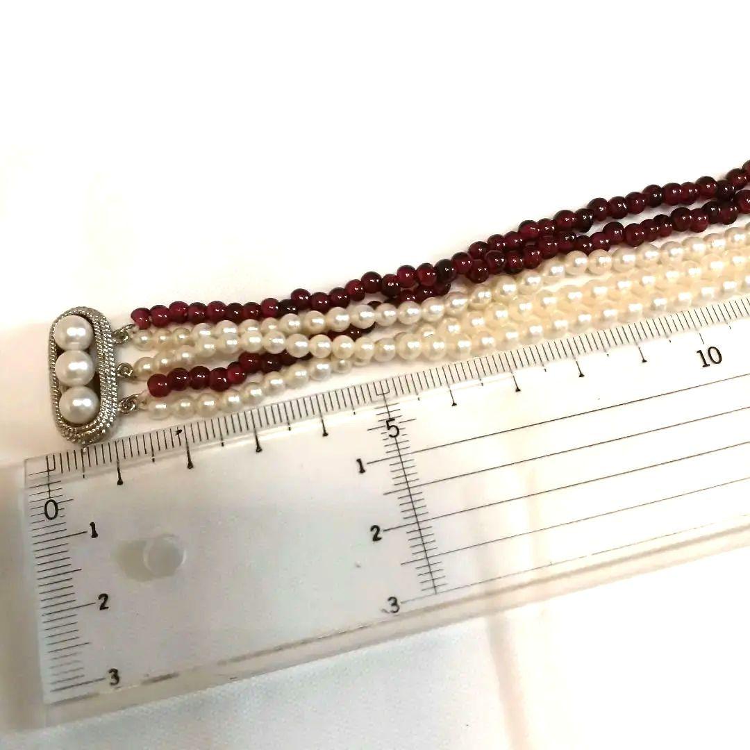 Five-row necklace with small round Akoya baby pearls and garnet stones showcasing high luster