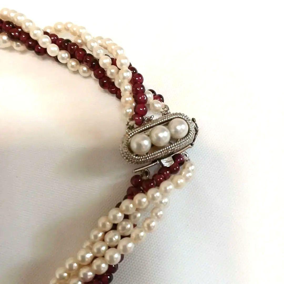 Five-row necklace with small round Akoya baby pearls and garnet stones showcasing high luster