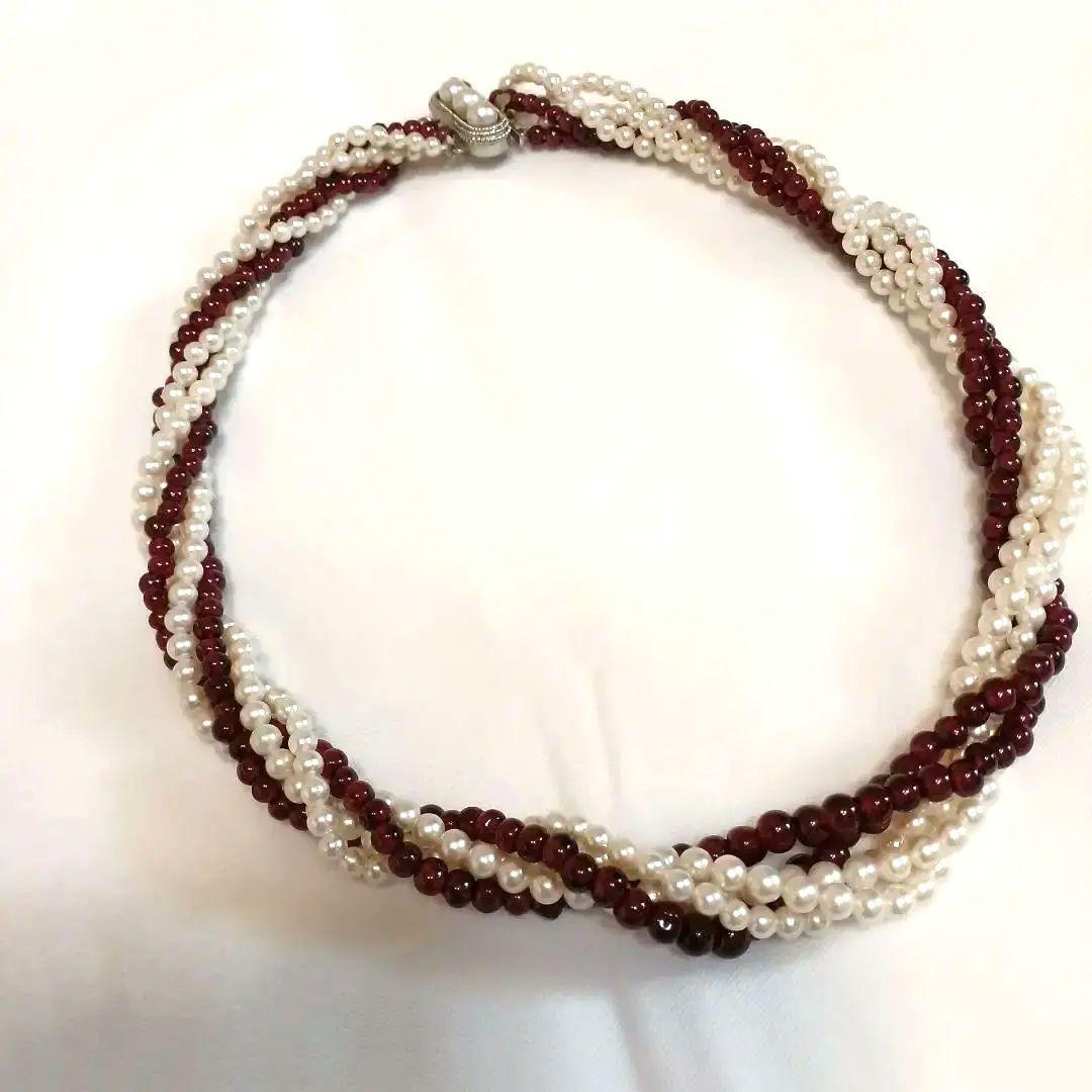 Five-row necklace with small round Akoya baby pearls and garnet stones showcasing high luster