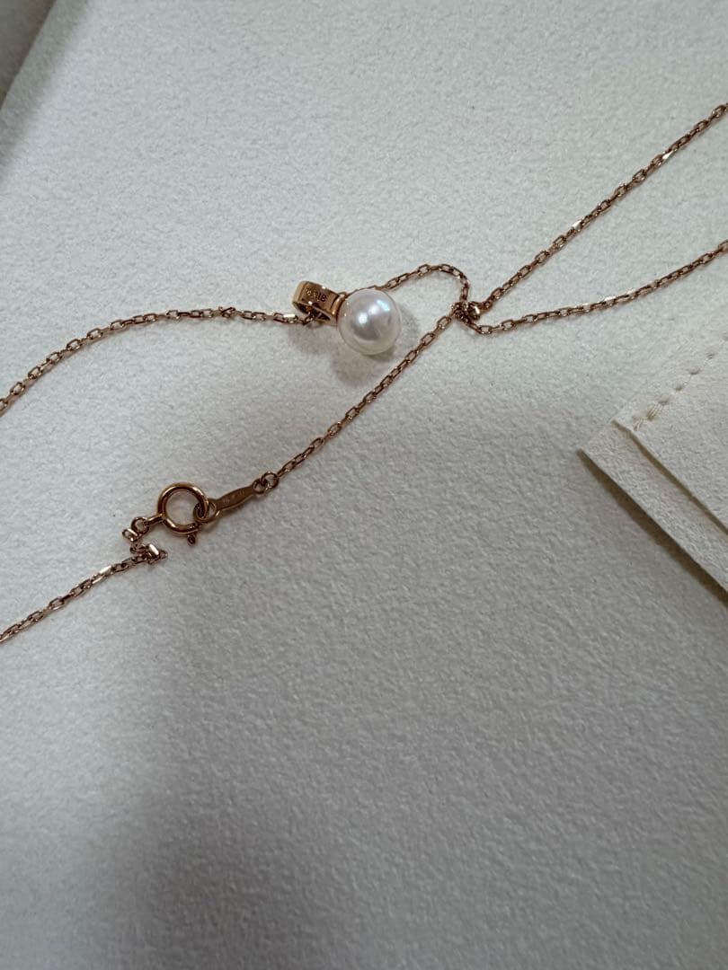 Mikimoto pink gold chain necklace with a single pearl pendant on white background