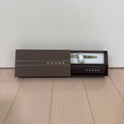 Gold CROSS ballpoint pen with diamond cut design displayed alongside original box