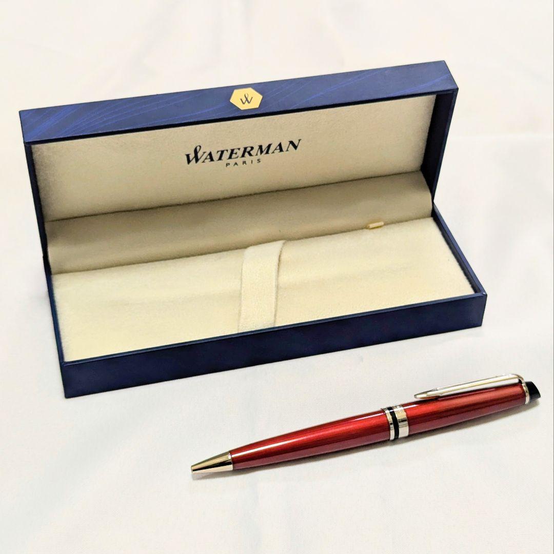 Waterman Expert dark red metal ballpoint pen with twist design alongside dedicated case