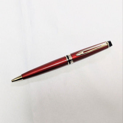Waterman Expert dark red metal ballpoint pen with twist design alongside dedicated case