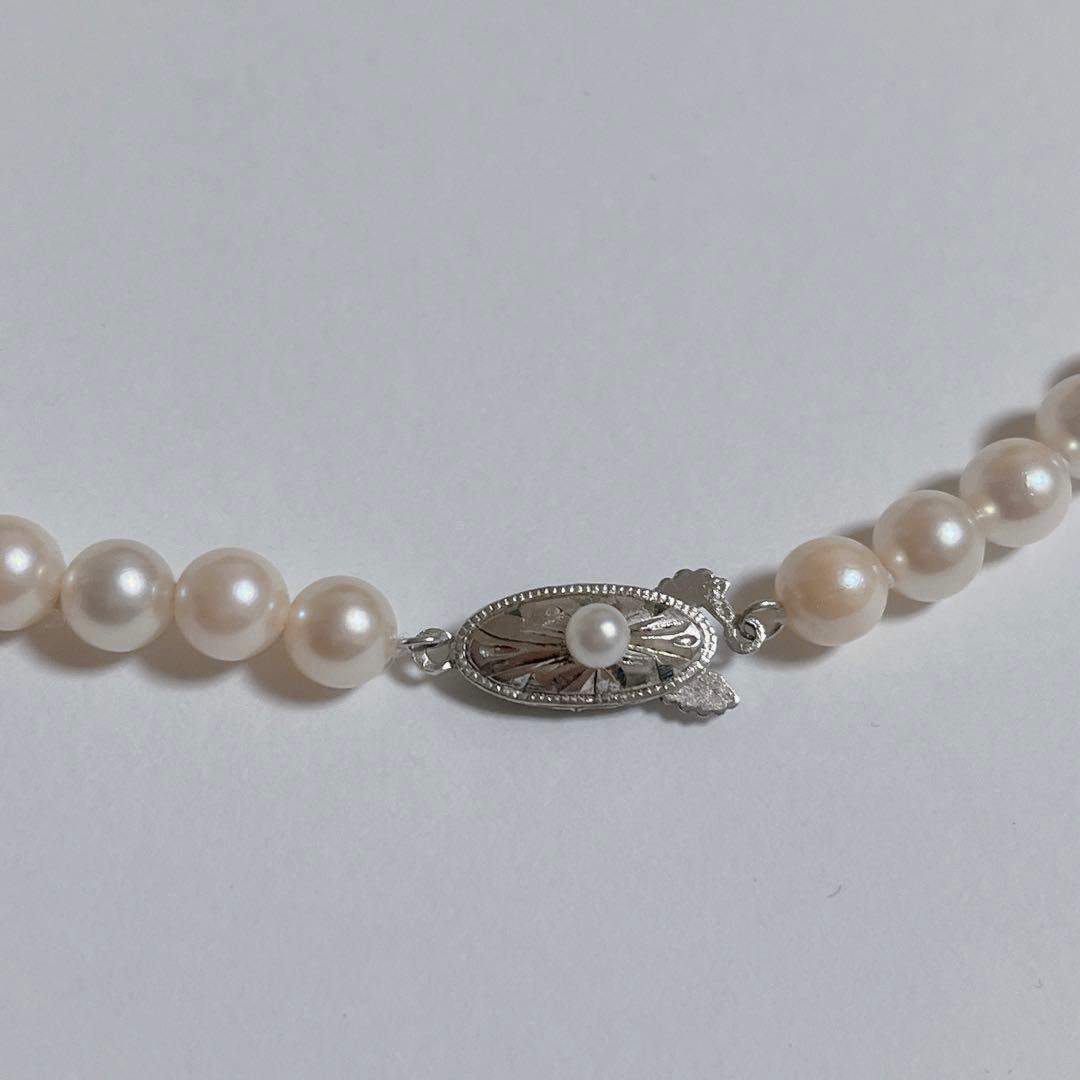 Close-up of 40cm Akoya pearl necklace with 6mm to 6.5mm pearls and silver engraved clasp on white background