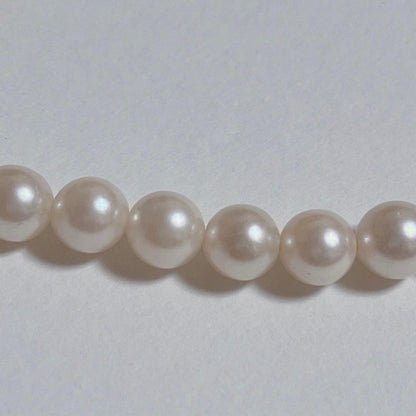 Close-up of 40cm Akoya pearl necklace with 6mm to 6.5mm pearls and silver engraved clasp on white background