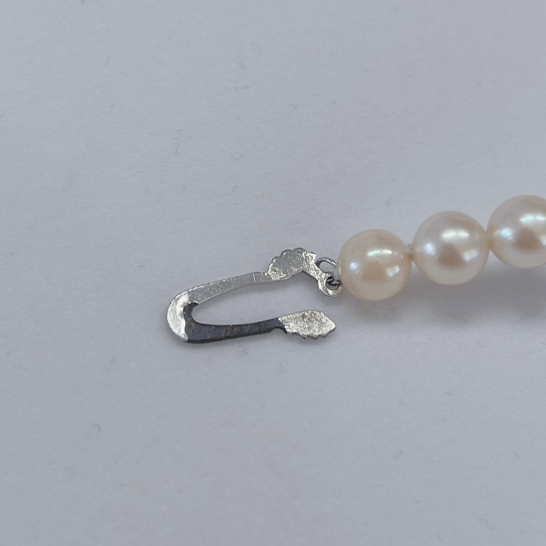 Close-up of 40cm Akoya pearl necklace with 6mm to 6.5mm pearls and silver engraved clasp on white background