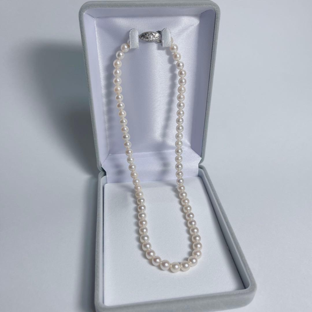 Close-up of 40cm Akoya pearl necklace with 6mm to 6.5mm pearls and silver engraved clasp on white background