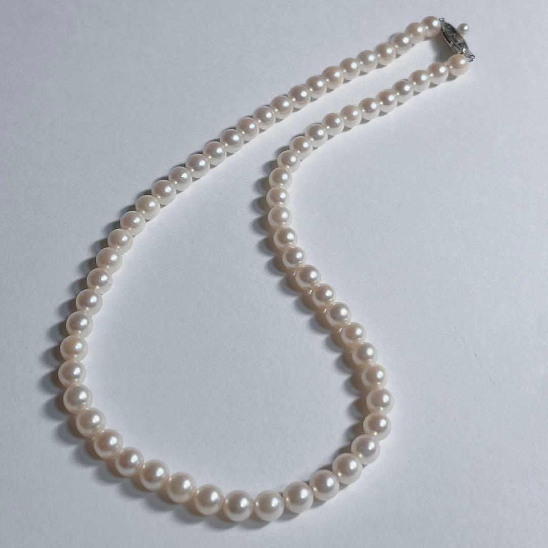 Close-up of 40cm Akoya pearl necklace with 6mm to 6.5mm pearls and silver engraved clasp on white background