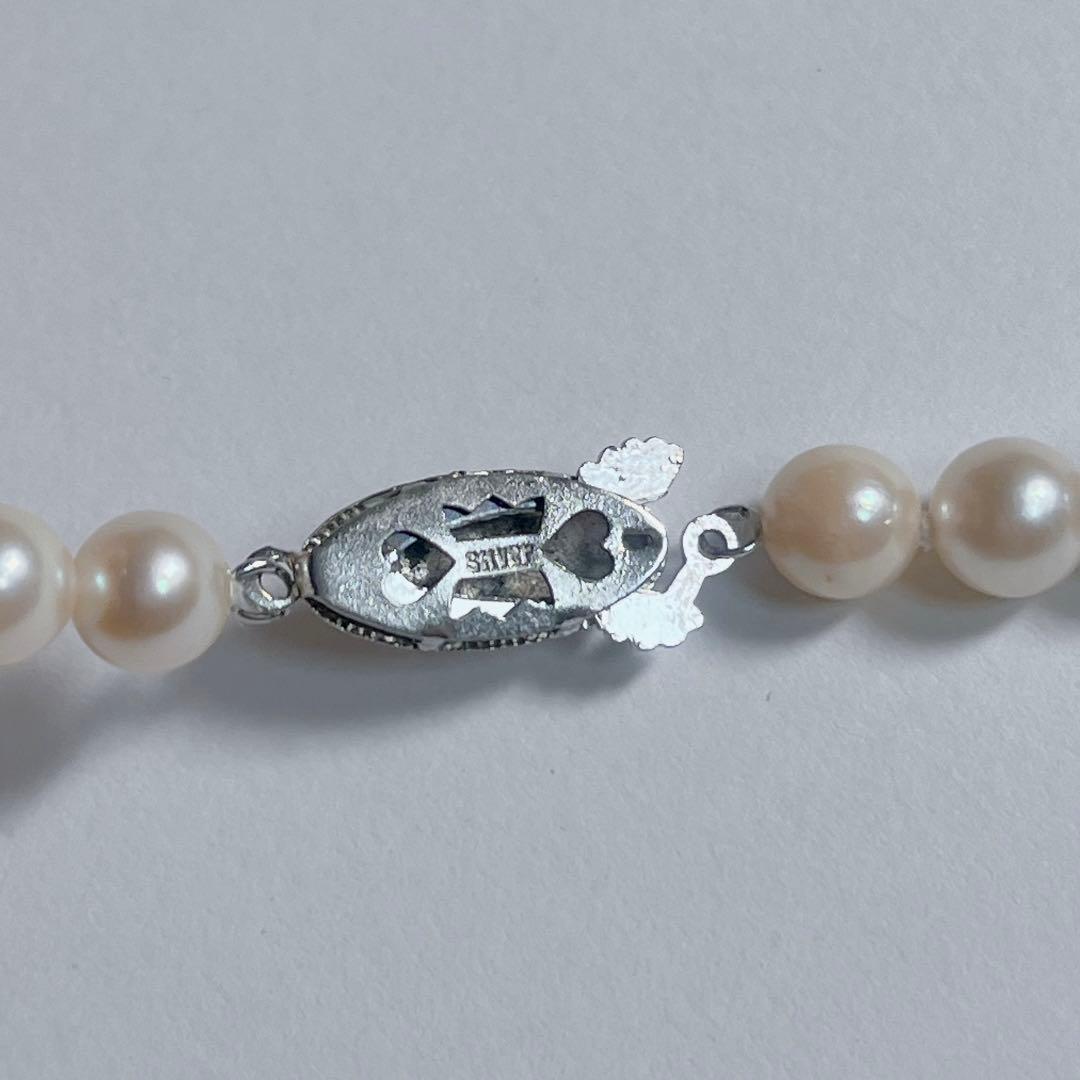 Close-up of 40cm Akoya pearl necklace with 6mm to 6.5mm pearls and silver engraved clasp on white background