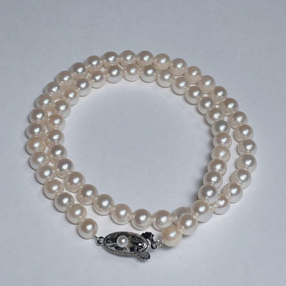 Close-up of 40cm Akoya pearl necklace with 6mm to 6.5mm pearls and silver engraved clasp on white background