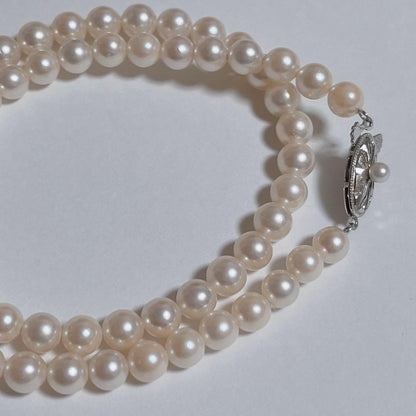 Close-up of 40cm Akoya pearl necklace with 6mm to 6.5mm pearls and silver engraved clasp on white background