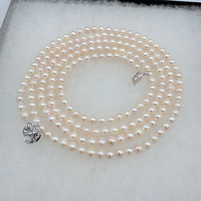 Long Akoya pearl necklace measuring 126cm with round 6.5mm white pearls on display