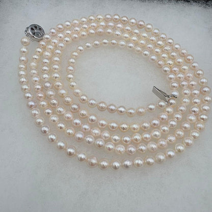 Long Akoya pearl necklace measuring 126cm with round 6.5mm white pearls on display