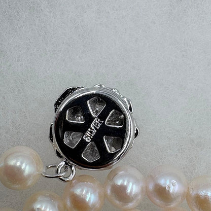 Long Akoya pearl necklace measuring 126cm with round 6.5mm white pearls on display