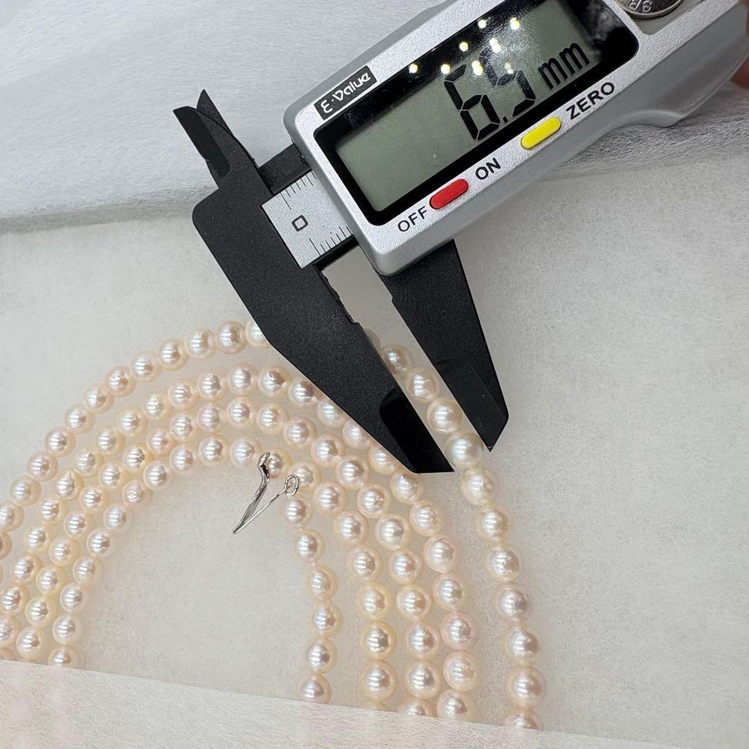 Long Akoya pearl necklace measuring 126cm with round 6.5mm white pearls on display