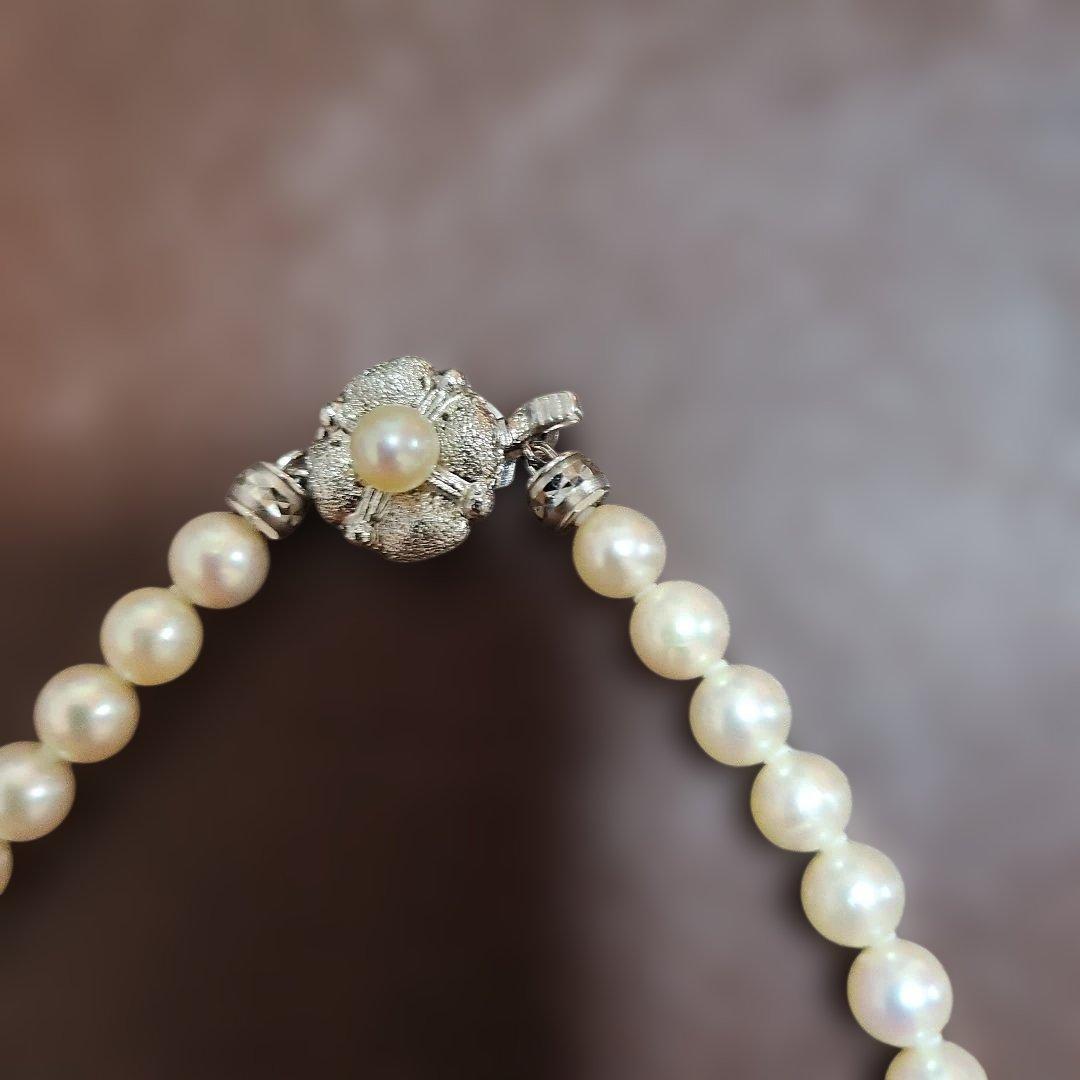 Akoya pearl necklace featuring lustrous pearls and a pearl decorated matte silver insertion clasp