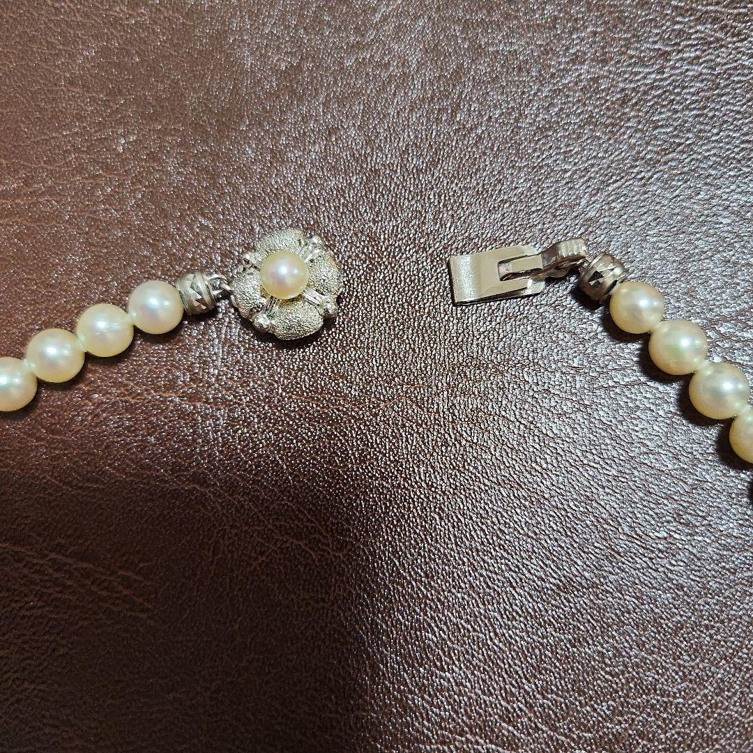 Akoya pearl necklace featuring lustrous pearls and a pearl decorated matte silver insertion clasp