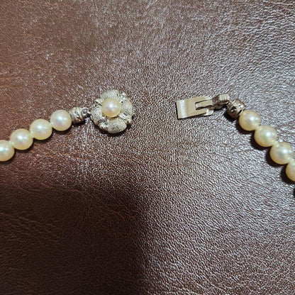 Akoya pearl necklace featuring lustrous pearls and a pearl decorated matte silver insertion clasp