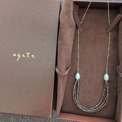 Elegant Agatte necklace with three strands of gray and white pearls and beads