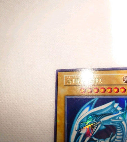 Yugioh Blue-Eyes White Dragon Early Ultra Rare trading card in protective sleeve and hard case