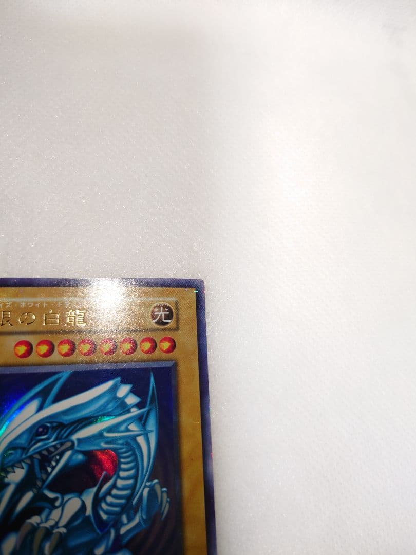 Yugioh Blue-Eyes White Dragon Early Ultra Rare trading card in protective sleeve and hard case