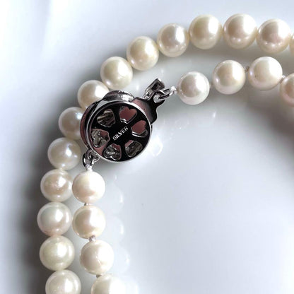 Akoya pearl necklace with white 6.0 to 6.5mm pearls and silver clasp on a white background