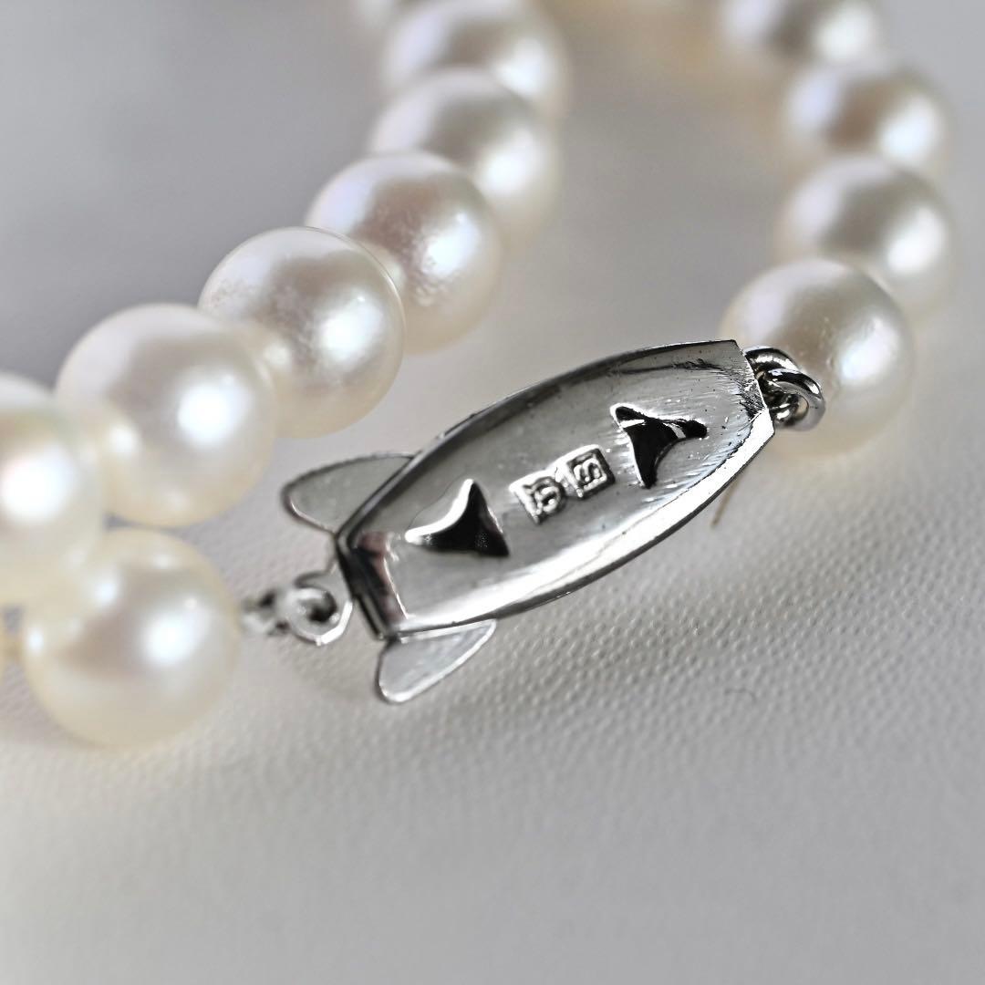 Tasaki Akoya Pearl Necklace featuring 7mm round pearls and a silver clasp on a white background