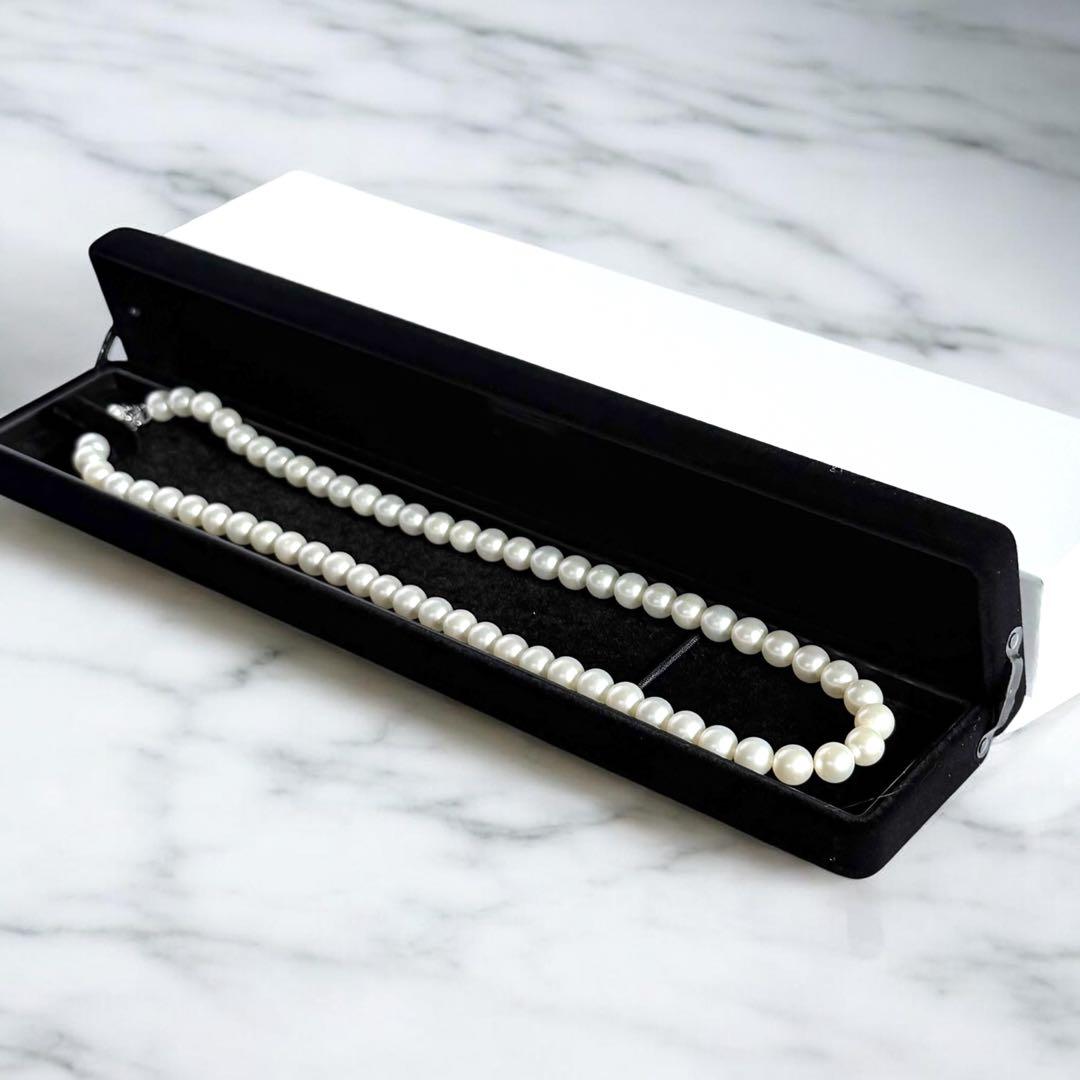 Tasaki Akoya Pearl Necklace featuring 7mm round pearls and a silver clasp on a white background